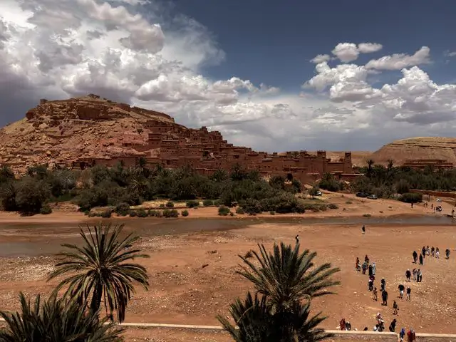 Ait Benhaddou kasabası, Fas'ta palmiye ağaçları ve toprak yapılarıyla çevrili nehir manzarası