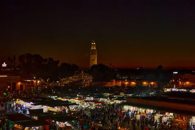 Marakeş Cemaʿa el-Fnaa meydanı gece pazarı ve Koutoubia Camii minaresi, Fas